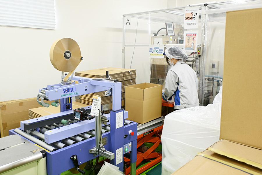充填され、ダンボールで外梱包された後にパレット積みを行う